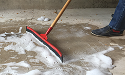 People cleaning up soapy water in garage