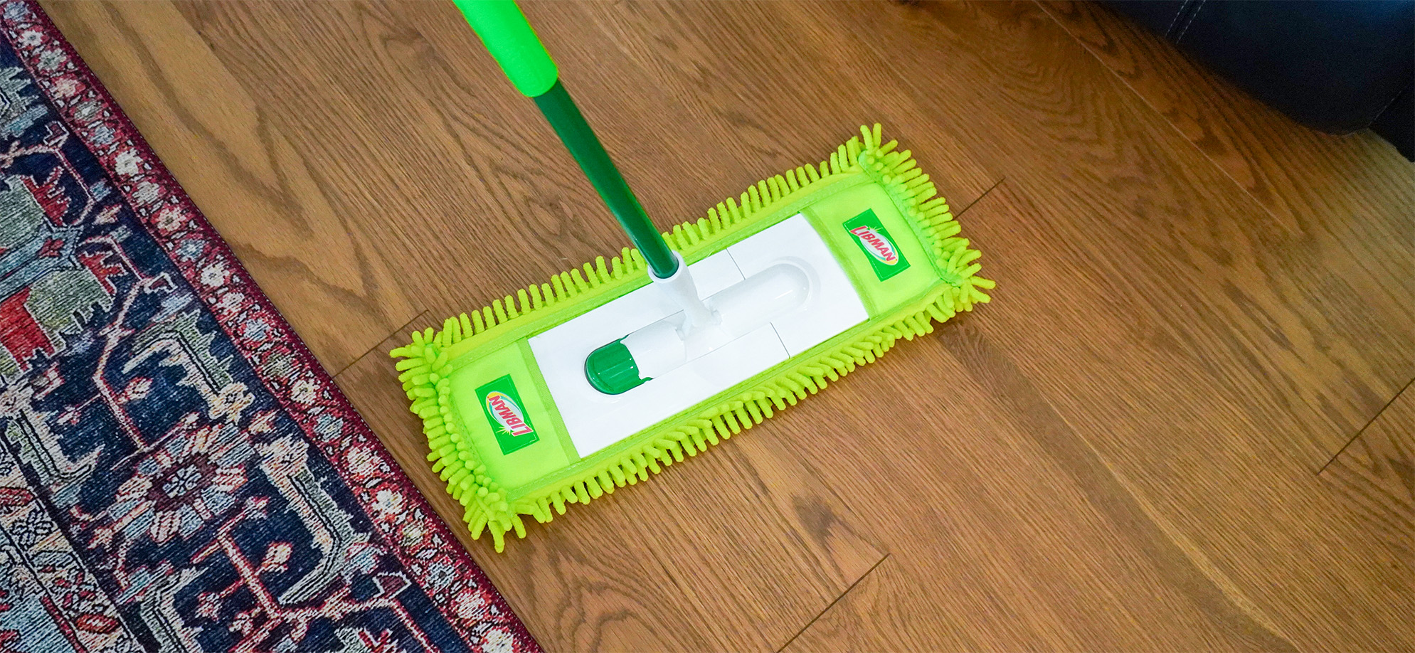 Dust mop being used to clean wood floor