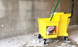 Yellow mop bucket in basement