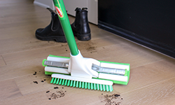 Mop head scrubbing mud off of wood floor