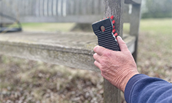 Person cleaning fence post with handheld scrub brush